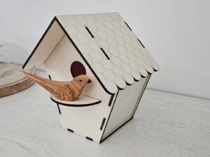 Oiseau chantourné en olivier sur nichoir découpé au laser